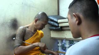 A devotee gets an oil sak yant on his forehead in Wat Bang Phra  Thailand [upl. by Nayrda]